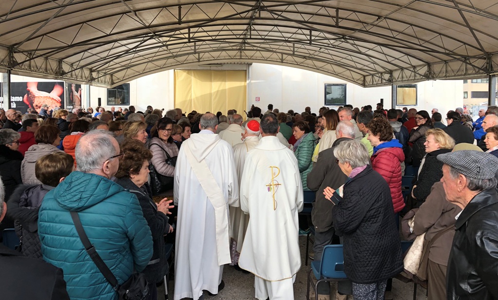 Perugia: Un popolo in festa per il lavoro e la solidarietà davanti alla cappella dell’Assunta, nel cuore della zona industriale di San Sisto-Sant’Andrea della Fratte. Il cardinale Gualtiero Bassetti: «Vogliamo che il lavoro, che è pane e vita, non manchi a nessuno» e sulla crisi in Siria ha ricordato le parole del nunzio apostolico cardinale Mario Zenari: «La Siria, ormai da diversi anni, è cinque volte l’inferno»